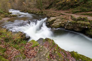 Long exposure of the Watersmeet Bridge waterfall on the East Lyn river at Watersmeet In Exmoor National Park in autumn