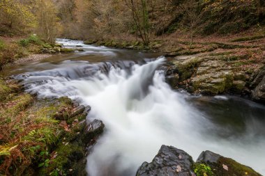 Long exposure of the Watersmeet Bridge waterfall on the East Lyn river at Watersmeet In Exmoor National Park in autumn