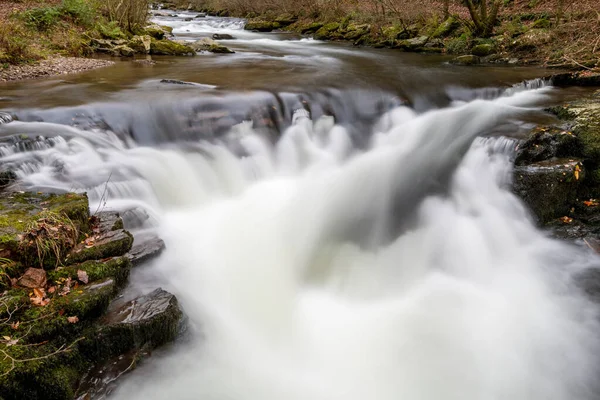 Long exposure of the Watersmeet Bridge waterfall on the East Lyn river at Watersmeet In Exmoor National Park in autumn