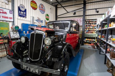 Sparkford. Somerset. Birleşik Krallık. 26 Mart 2023.A 1938 Morris Sekiz Salonu Somerset 'teki Haynes Motor Müzesi' nin eski moda bir garajında sergileniyor.