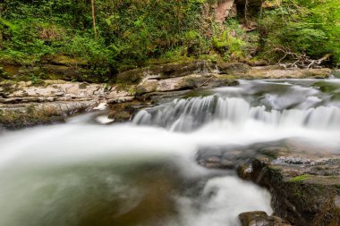 Doğu Lyn nehrinin üzerinde Exmoor Ulusal Parkı 'ndaki Watersmeet' te akan şelalenin uzun pozu