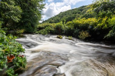 Doğu Lyn nehrinde Exmoor Ulusal Parkı 'ndaki Doone Vadisi' nden akan bir şelalenin uzun pozu