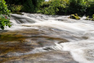Doğu Lyn nehrinde Exmoor Ulusal Parkı 'ndaki Doone Vadisi' nden akan bir şelalenin uzun pozu