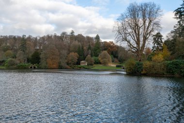 Wiltshire 'daki Stourhead bahçesindeki gölün etrafındaki sonbahar renklerinin görüntüsü