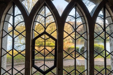 Stourhead 'deki sonbahar renklerinin Gotik kulübesinin penceresinden bak