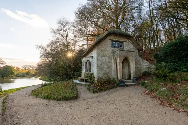 Güneş, Wiltshire 'daki Stourhead Bahçeleri' ndeki Gotik Kulübe 'nin arkasında batıyor.