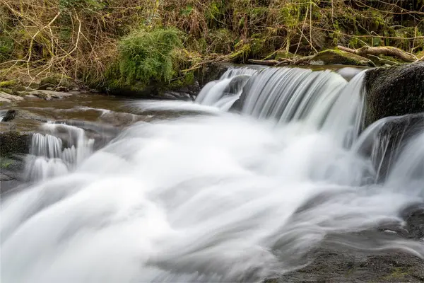 stock image Long exposure of a waterfall on the Hoar Oak Water river at Watersmeet in Exmoor National Park