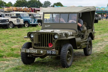 Low Ham.Somerset.United Kingdom.July 20th 2024.A restored Willys jeep is being driven around the arena at the Somerset Steam and Country show clipart