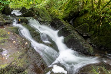 Long exposure of a waterfall on the Hoar Oak Water river at Watersmeet in Exmoor National Park clipart