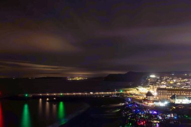 Batı Bay.Dorset. Birleşik Krallık. 19. 2023. Cadde. Dorset 'teki West Bay' de bir grup insan fener alayı için bekliyor.