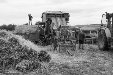 Haselbury Plucknet. Somerset. Birleşik Krallık. 17 Ağustos 2024. Coşku, antika bir harman makinesinin nasıl çalıştığını gösteriyor.