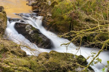 Doğu Lyn nehrinin üzerinde Exmoor Ulusal Parkı 'ndaki Watersmeet' te akan şelalenin uzun pozu