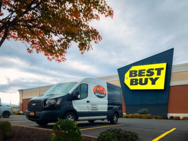 New Hartford, New York - 19 Ekim 2022: İnek Takımı Siyah ve Beyaz Minibüsü ve Arka plandaki Best Buy Binası Manzarası.