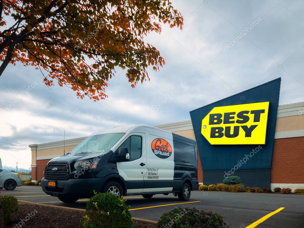 New Hartford, New York - Oct 19, 2022: Landscape Wide View of Geek Squad Black and White Van in Foreground and Best Buy Building in Background.
