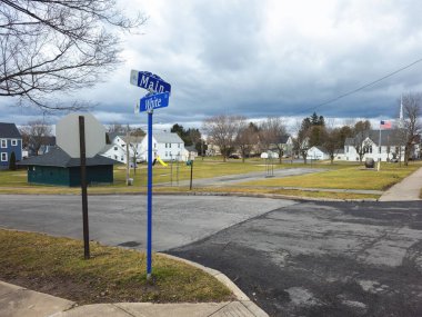 New York Mills, New York - 10 Mar 2024: Arka planda Polaski Parkı ve ön planda Main St ve White Caddesi tabelası