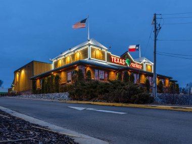 New Hartford, New York - 19 Mart 2020: Texas Roadhouse Restoran Konumu Gece Manzarası, 2020 itibariyle 450 'den fazla yerde Batı temalı biftek sunan bir zincir restorandır..