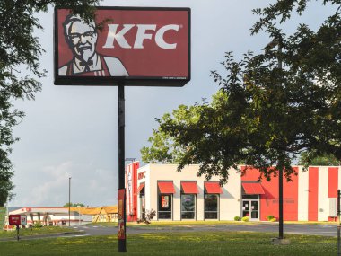 Utica, NY - 14 Temmuz 2025: KFC Pole tabelasının (Kentucky Fried Chicken) simgesel kızarmış tavuğu ve gizli bitki ve baharat karışımıyla bilinen çok geniş çaplı güneşli manzarası, KFC dünya çapında 25.000 'den fazla yeri işletiyor.