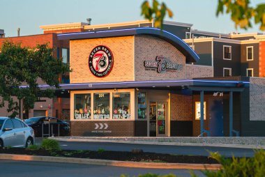 Roma, New York - 23 Temmuz 2025: 7 Brew Coffee 'nin altın saat manzarası, çift şeritli servis yolları, hız ve müşteri hizmetleri ve çeşitli içeceklerle bilinen tek kahve zinciri.