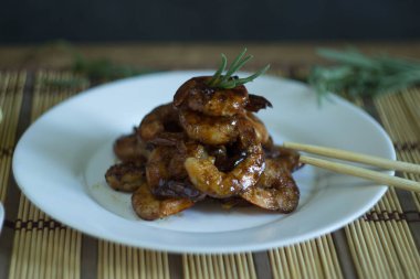 Beyaz tabakta soya soslu kızarmış karides..