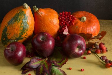 Sonbahar, balkabağı, elma, kestane ve sonbahar yapraklarıyla dolu karanlık ahşap bir arka planda. Sonbahar hasadı