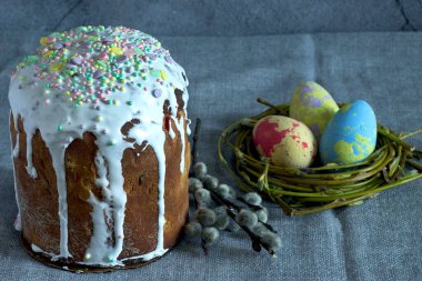 Koyu arkaplanda renkli yumurtalar ve paskalya yumurtaları ile boyalı bir peçeteyle pasta.