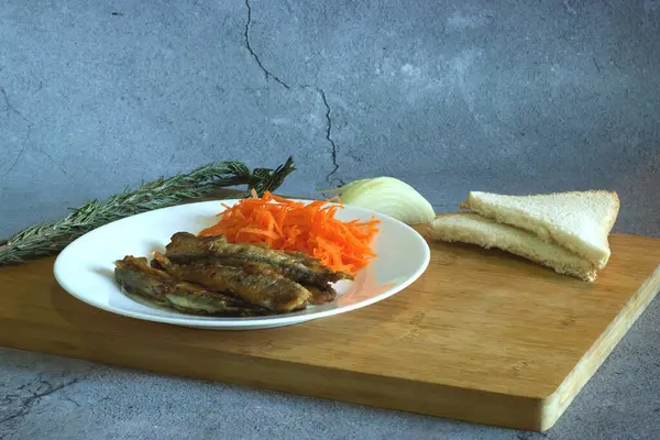 fish with vegetables and herbs on a wooden table