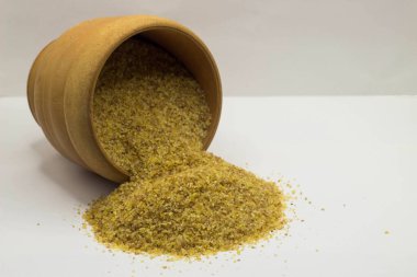 Buğday gevreği bir kabın içine döküldü, buğday filizleri beyaz arka planda bir yığın halinde dağıldı.