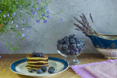 Taze yaban mersini, ahududu, bal ve süt dolu bir tabakta kahvaltı