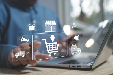 İnternetten konsept alışveriş. El işi alışverişçisi, el arabası simgesine dizüstü bilgisayar dokunuşu kullanıyor. iş, mağaza, e-ticaret teknolojisi İnternet, İnternet üzerinden alışveriş hizmeti ve ev teslimatı sunar.