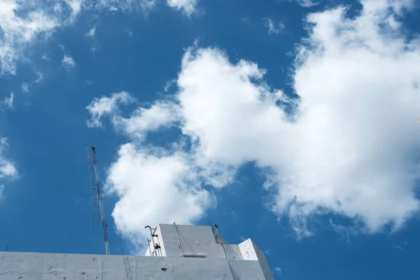 Antenna Pole on the Top of Old Building with White Cloud and Blue Sky Background in Minal Style.