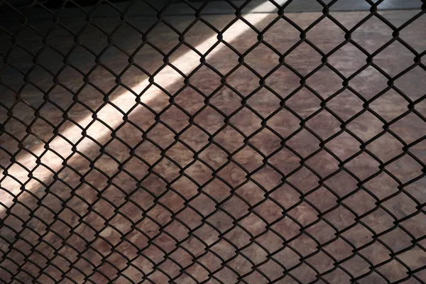 光ビームの背景を持つ亜鉛メッキ金属フェンス — ストック写真