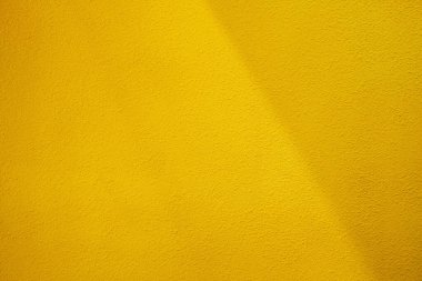 Işık Işını ve Gölgesi Olan Sarı Stucco Duvarı.