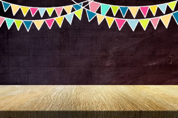 Wood Table with Colorful Party Flags in Chalk Drawing Style on Old Grunge Chalkboard Background, Suitable for Product Presentation Backdrop, Display, and Mock up in Party Concept.