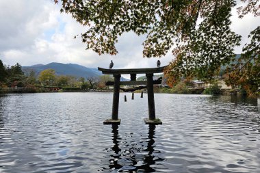 Antik Torii, Sonbaharda Kinrin Gölü 'nde. Japonya 'nın Oita bölgesinde Yufuin' in ünlü bir simgesidir..