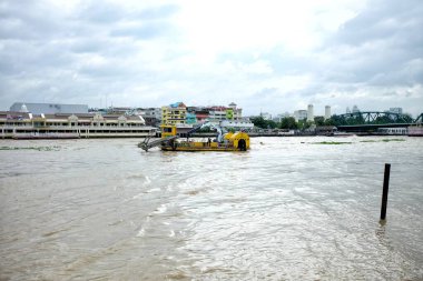 BANGKOK, THAILAND - 18 Temmuz 2017: Chao Phraya Nehri 'ndeki Sucul ot biçme makinesi. Tayland Kraliyet Sulama Departmanı başkentte su baskınını önlemek için nehirdeki sümbülleri temizlemek için kullanır..