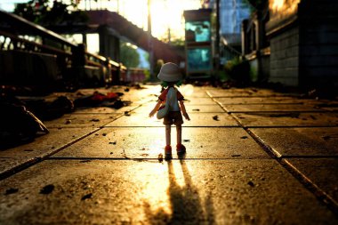 BANGKOK, THAILAND - 23 Kasım 2017: Minyatür Yotsuba Koiwai anime figürü güzel bir günbatımı arka planına sahip yolda duruyor. Meşhur Japon komedi serisi..