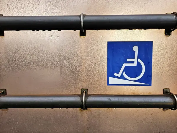 Disabled Ramp Access Sign with metal handrail on tram station.