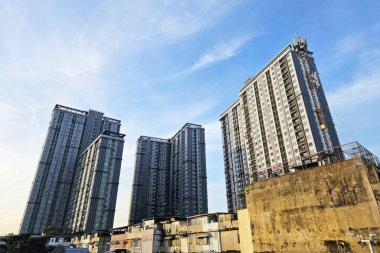 Bulutlu Gökyüzü Arkaplanı ile Modern Kondominyum Binası ve Eski Bina.