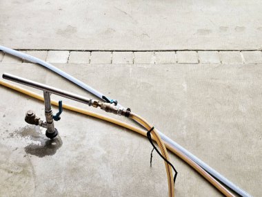 Hortum ve musluğa bağlı metal bir boru, yere termitisit enjekte etmek için kullanılır..