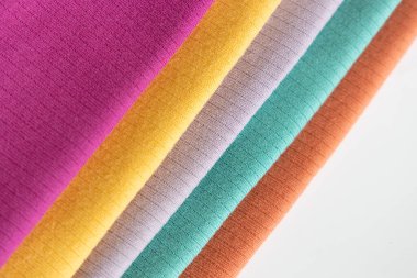 Beyaz arka plan izolasyonunda katlanmış mor, sarı bebek pamuğu giysisi..