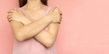 Embrace equity. Woman hug yourself dressed pastel pink dress on pink background. International womens day concept. Pastel colors, copy space