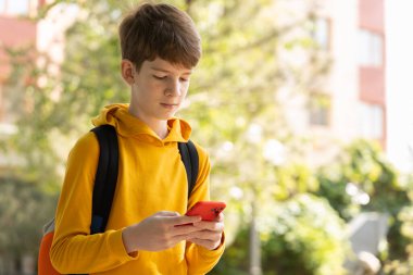 Akıllı telefon kullanan bir gencin portresi. Blog yazma, sörf, video görüşmesi. Z jenerasyonu, mobil jenerasyon. Düşük açı görünümü, boşluk kopyala