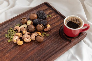 A tasty charcuterie board full of various nuts and coffee for breakfast clipart