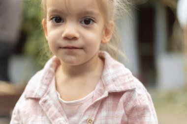 Küçük kız portresi, umutla kameraya bakıyor..