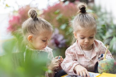 Renkli kalemlerle resim yapan iki kız birlikte vakit geçiriyorlar..