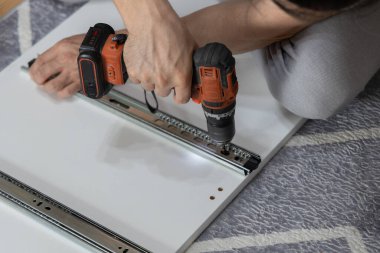 Tornavidayla mobilya montajının ayrıntılı görünümü, ellerin kapatılması.