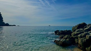 Lloret de Mar 'da güneşli plaj ve köpüklü dalgalar. Resimli sahne yaşam tarzı, rahatlama ya da seyahat tutkusu kavramları için mükemmel.