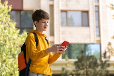 Apartmanın önünde genç bir çocuk akıllı telefonuna bakıyor ve gülümsüyor. Mutluluğu çevrimiçi iletişimden yakalıyor, arkadaşlarla sohbet ediyor ve bağlantıda kalıyor.. 