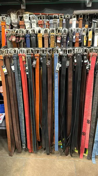 BARCELONA, SPAIN- MAY, 28, 2024: Bir perakende mağazasında raflarda düzgün bir şekilde düzenlenmiş renkli deri kemerler.