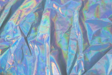 Parlak yanardöner yüzeyi ve renkli yansımaları olan holografik dokuyu kapat. Moda, tasarım ve yaratıcı projeler için moda tekstil arka planı